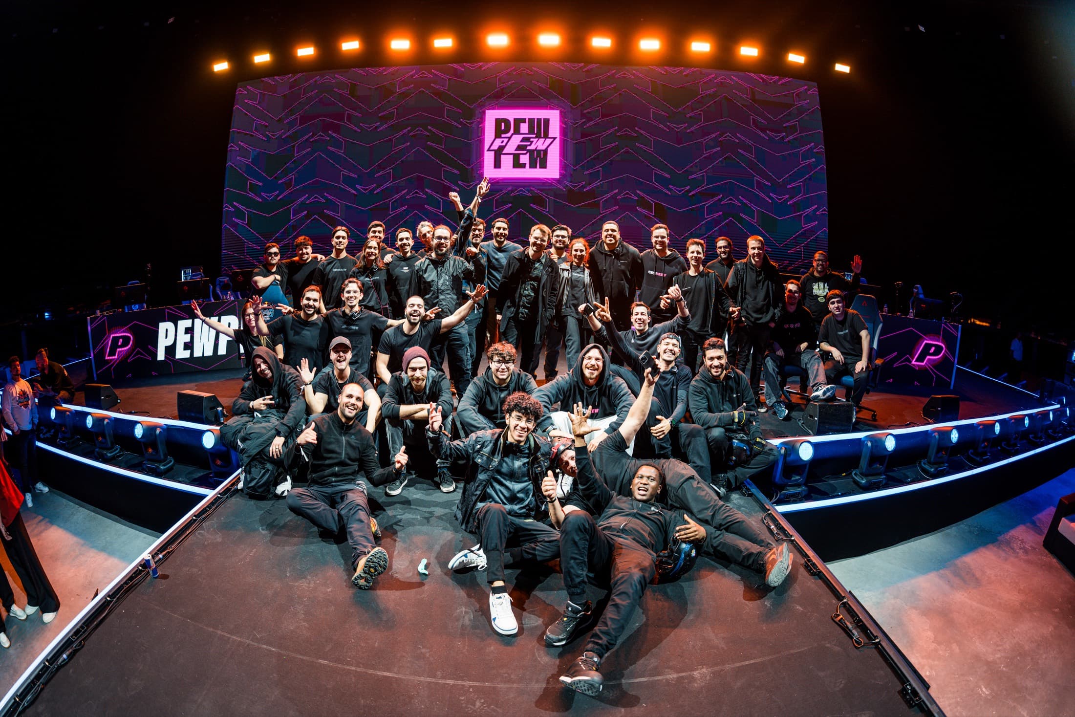 The PEW PEW crew on stage in front of an LED wall with the PEW PEW logo